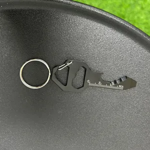 Close-up detail of black multi-tool key ring showing etched scale and functional cutouts.