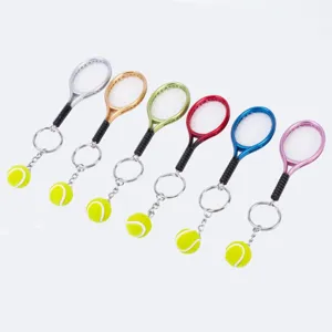 Metal tennis racket keychain with miniature ball pendant, colorful souvenir sports gift.