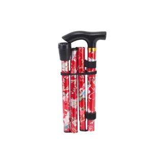 Détail de canne de marche pliante, motif floral rouge portable et poignée en T noire.