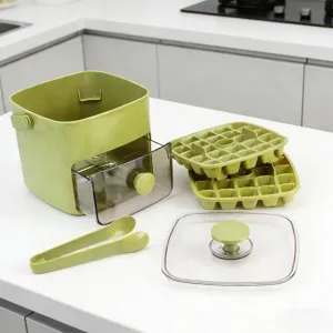 Nahaufnahme zeigt die Komponenten der gruenen Eisbereiterbox, Schaalen und Zange.