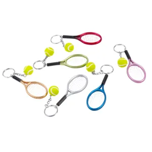 Detailed shot of colorful mini tennis racket and ball keychains, metal ring accessories.