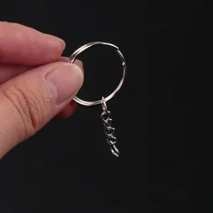 Inquadratura di dettaglio di portachiavi in metallo argentato con catena e anello.