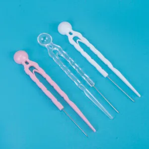Vue detaillee outil auxiliaire bricolage perles a repasser, manche plastique avec aiguille.