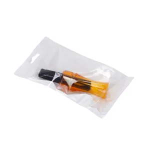 Closeup view and details of the plastic crow hunting call whistle in clear packaging bag.