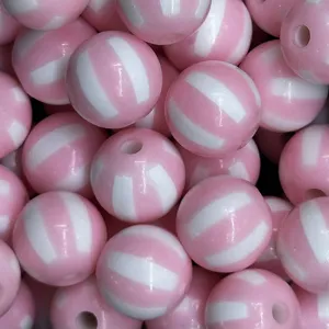 Primer plano de cuentas acrílicas rayadas en rosa y blanco para joyería y accesorios DIY.