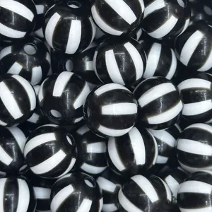 Detalles en primer plano de cuentas de acrílico con rayas blancas y negras para bisutería.