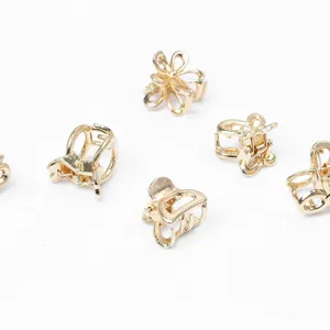 Vue détaillée de petites pinces à cheveux dorées en métal avec des motifs de papillons.