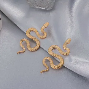Primer plano detallado de pendientes de serpiente dorados 3D, tachuelas punk vintage de aleación.