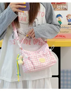 Pink and white plaid crossbody bag detail, cute pendant and stylish casual design.