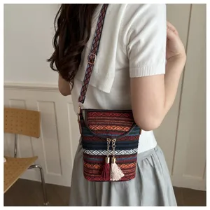 Böhmische gewebte Umhängetasche für Damen mit bunten geometrischen Riemen und schicken Quasten.