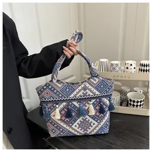 Ethnic style tassel striped tote bag, fashionable woven handbag for casual travel and street snapshot.