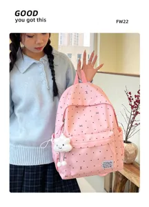 Détail de sac à dos rose à pois avec joli pendentif nuage, idéal pour un look quotidien.
