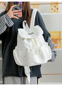 Detail view of the cute white star pattern canvas backpack with drawstring and pocket.