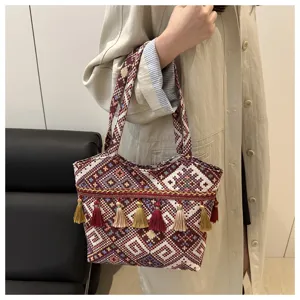 Detailed view of ethnic style woven tote bag with colorful tassels, casual daily use.