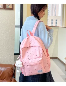 Détail de sac à dos rose mignon à pois et nœud, cartable scolaire décontracté avec pendentif nuage.
