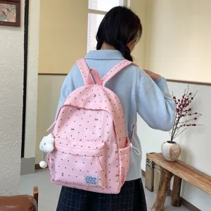 Vue détaillée du sac à dos rose à pois avec motif nœud mignon et pendentif en peluche.