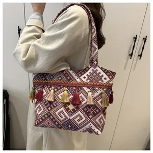 Ethnic woven shoulder bag detail view featuring colorful geometric pattern with tassels.