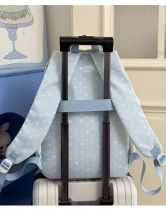 Hellblaue Studenten Rucksack mit Sternen Muster, Koffer Gurt Detail für bequeme Reise Nutzung.
