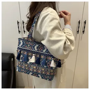 Ethnic woven tote bag detail showing intricate geometric patterns and stylish blue tassels.