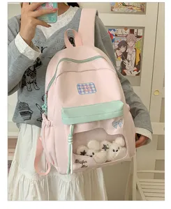 Rosa hellblauer Schülerrucksack mit transparenter Vordertasche und niedlichen Plüschtieren.