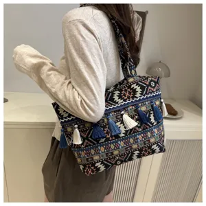 Ethnic style woven tote bag with tassels, stylish and versatile shoulder bag for women.