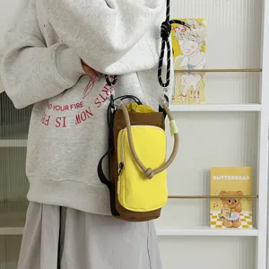 Close-up detail of a stylish color-blocked canvas crossbody water bottle bag with drawstring.