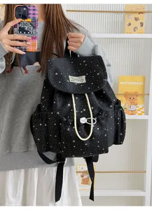 Black canvas star print backpack detail showing front pocket and drawstring design.