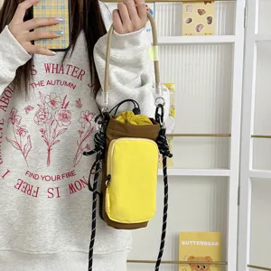 Detail shot of the colorblock crossbody water bottle bag with front pocket and drawstrings.