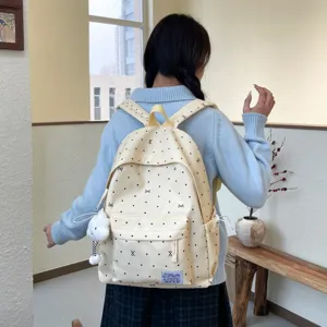 Vue détaillée du sac à dos à pois mignons, avec grande poche avant et matériau souple.