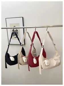 Minimalist solid nylon shoulder bag, casual hobo crossbody bag with cute plush pendant for women.