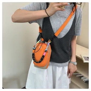 Detail view of the color-block braided crossbody mini phone bag with stylish strap.