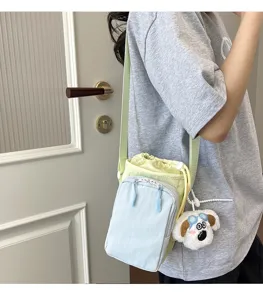 Korean style color block mobile phone cross-body bag with cute puppy plush charm pendant.