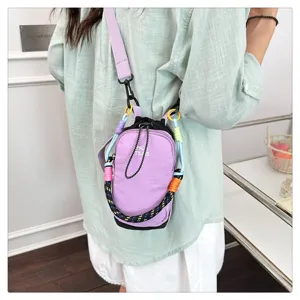 Detailed shot of trendy purple mini crossbody phone bag with colorful braided straps for outdoor wear.