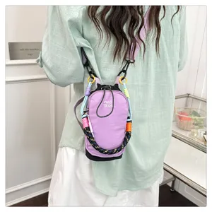 Detailed view of mini purple crossbody phone bag with colorful woven strap and drawstring.