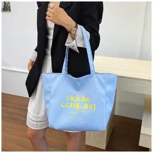 Detail view of large capacity nylon tote bag with stylish printed text and casual design.