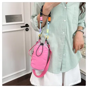 Mini crossbody phone bag, stylish pink nylon fabric with colorful braided strap details.