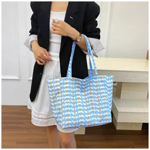 Detail shot of a blue and white wave-patterned tote bag with sweet orange dots, perfect daily style.
