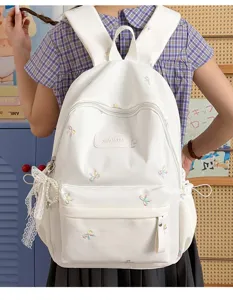 Cute white student school backpack detail showing bow embroidery and large daily capacity.