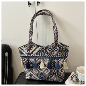 Detailed view of the ethnic style woven tote bag showcasing colorful patterns and hanging tassels.