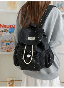 Detailed view of the black star print backpack featuring front pockets and drawstring closure.