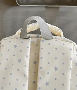 Nahaufnahme des niedlichen Rucksacks mit Sternenmuster, Tragegriff und stabilen Gurten.