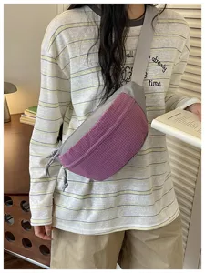 Detailed shot of a stylish color-block crossbody fanny pack with a trendy purple grid design.