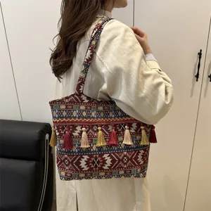 Ethnic style woven tote bag with vibrant tassels, fashionable shoulder bag for daily use.