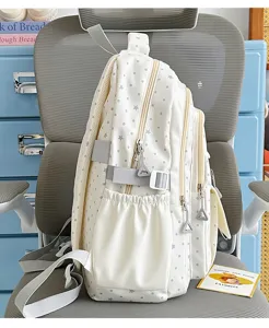 Detailansicht des niedlichen weißen Studentenrucksacks mit blauen Sternen und Seitentaschen.