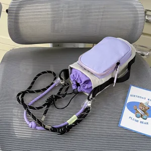 Detailed view of the purple and beige outdoor drawstring crossbody water bottle and phone bag.