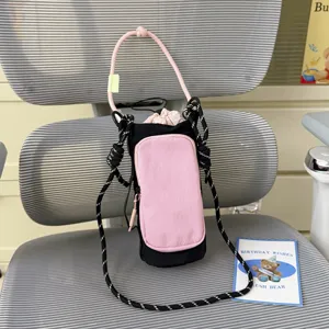 Detail view of the black and pink colorblock water bottle bag with strap for outdoor sports.