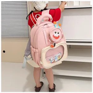Pink cartoon kids backpack with transparent pocket and funny monster design for kindergarten.