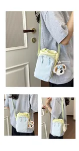 Detail view of the colorful dopamine crossbody phone bag with cute plush dog pendant.