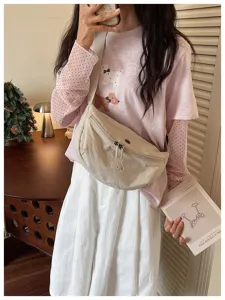 Detailed lifestyle showcase of casual nylon crossbody dumpling bag featuring wide shoulder strap.