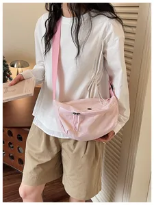 Lightweight pink dumpling crossbody bag, casual commuter shoulder bag with adjustable strap.